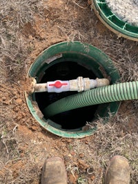 a man is standing next to a pipe in the ground